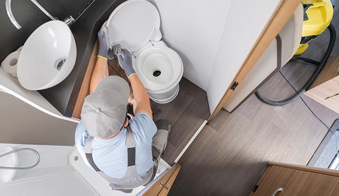 a professional performing maintenance on an rv toilet